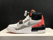 Side profile showing the grey side detail, black collar, coral heel overlay, patterned lower panel, and white midsole.