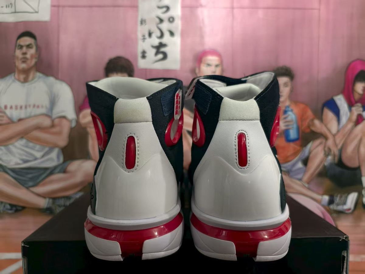 Rear view of navy, white, and red high-top basketball sneakers showing padded collars and red heel details.