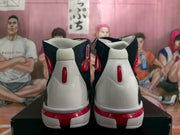 Rear view of navy, white, and red high-top basketball sneakers showing padded collars and red heel details.