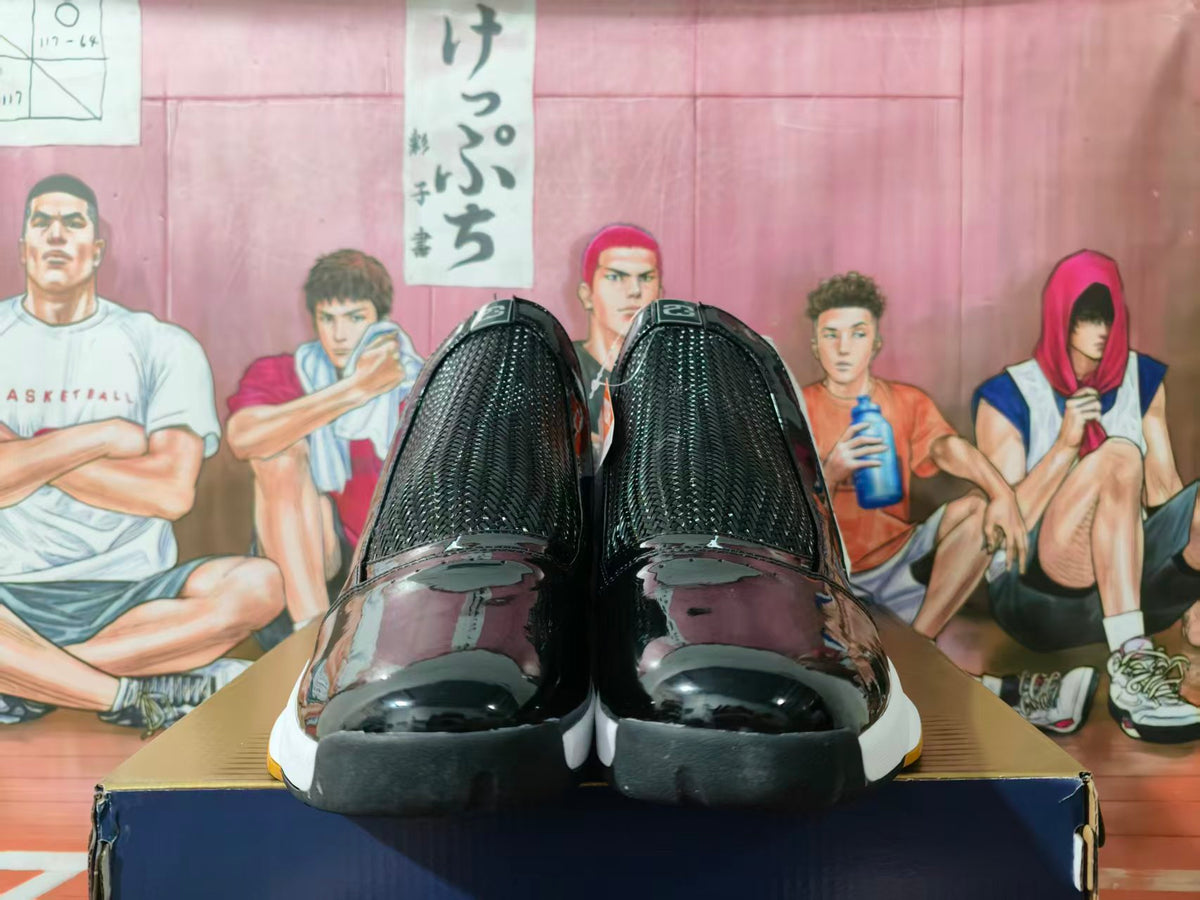 Front view of white and black high-top sneakers with glossy black toe sections and gum-colored outsole accents.