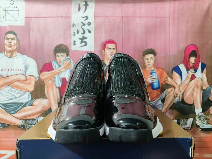Front view of white and black high-top sneakers with glossy black toe sections and gum-colored outsole accents.
