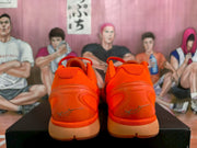 Rear view showing the orange padded collars, sculpted heels, and silver heel signatures.