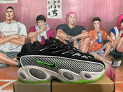 Side view of a black Nike sneaker showing the patterned side panel, green Swoosh, white midsole accents, and green outsole.