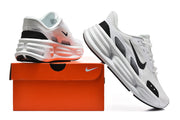 White and black Nike running sneakers displayed with an orange shoe box