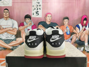 Rear view of black and white Nike Air sneakers with cream-toned midsoles and red outsole accents.