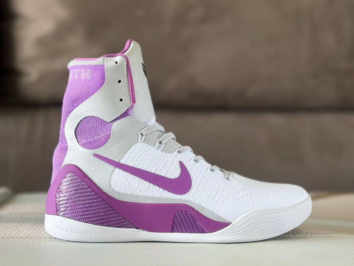 Side view of a white and purple Nike Kobe 9 high-top basketball shoe.