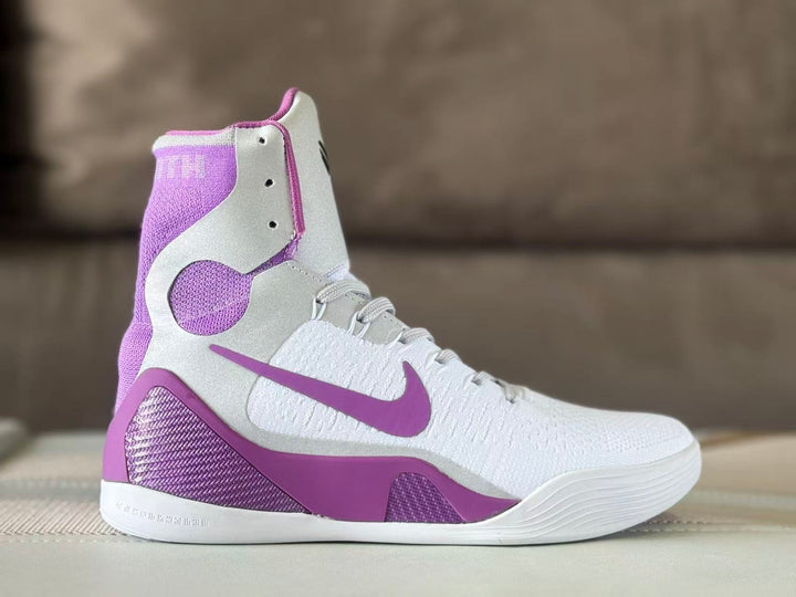 Side view of a white and purple Nike Kobe 9 high-top basketball shoe.