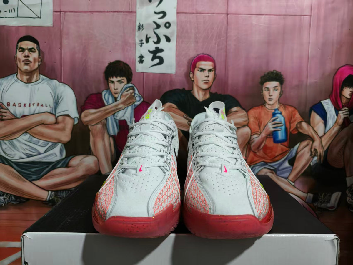 Front view of white Nike basketball sneakers with red translucent toe sections and graphic detailing.