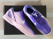 Top view of the pair showing the checkerboard collar lining, Kobe tongue emblem, purple laces, and violet-to-pink color transition.