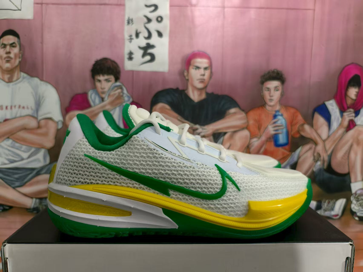 Side view of white Nike basketball sneakers with green and yellow details, textured panels and white laces.