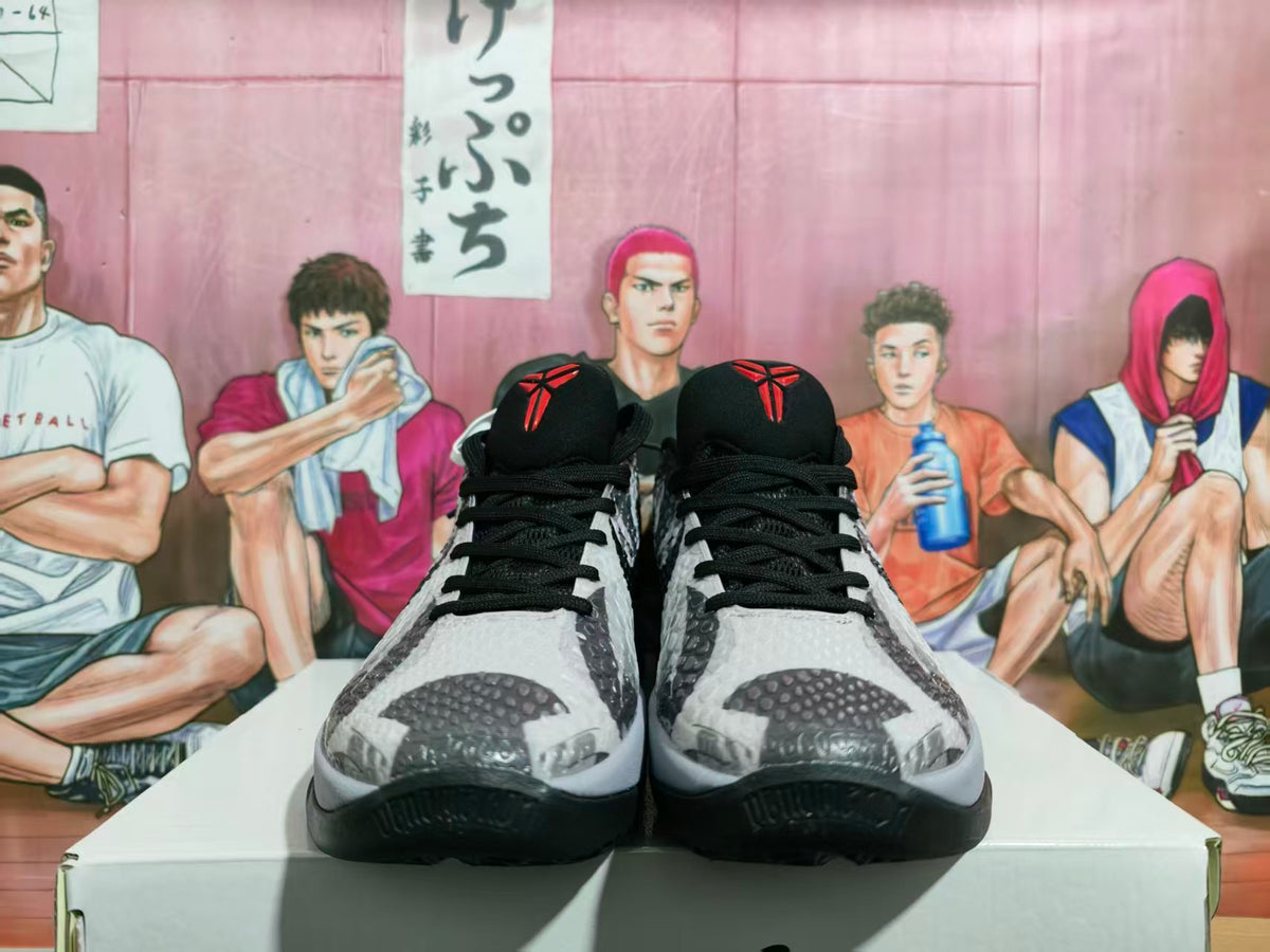 Front view of charcoal gray and black Nike basketball sneakers with textured uppers, black laces, and red tongue details.