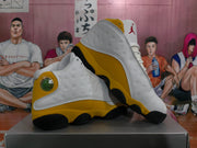 Pair of white and yellow Jordan high-top sneakers displayed at an angle