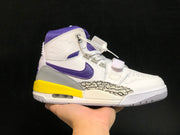 Close side view showing the purple Swoosh-style branding, yellow midsole section, heel air unit, strap, and elephant-print panel.