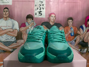 Front view of green basketball-style sneakers showing the lace-up design, darker green toe caps, and textured forefoot panels.