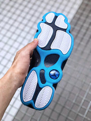 Outsole view showing white tread sections, black inserts, blue edging, and a circular underfoot detail.