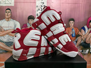 Angled view of the pair of red and white Nike basketball sneakers showing the side detailing, laces, white midsoles, and red outsole accents.