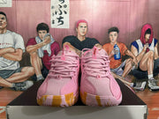 Front view of pink Nike basketball shoes with lace-up closure and perforated uppers