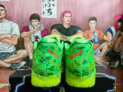 Rear view of the bright green sneakers showing red “TWOLVE” lettering on both heels and translucent textured outsoles.