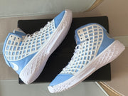 Angled top view of the pair showing the high-top construction, white outsoles, and side branding.