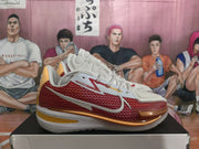 Side view of the white and red basketball sneaker with contrasting gold-toned outsole details.