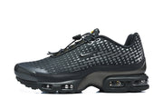 Side view of black Nike Air Max Plus sneakers with a dotted upper and visible sole cushioning.