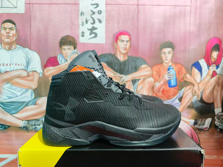 Side view of black and silver high-top basketball sneakers on a shoe box, showing the textured upper, lace-up construction, and patterned midsole.