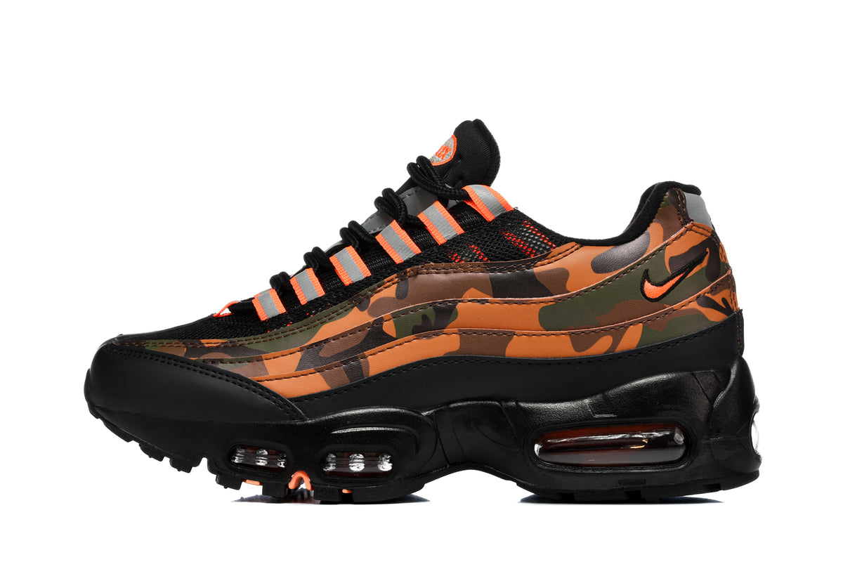 Side view of a Nike Air Max 95-style sneaker with orange, olive, and brown camouflage panels, black overlays, and orange accents.
