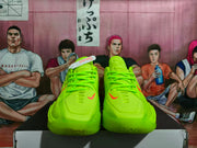 Front view showing the fluorescent green lace-up design, red swoosh accents and rounded toe boxes.