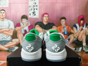 Rear view showing green padded collars, gray heels, white midsoles, and raised white heel emblems.