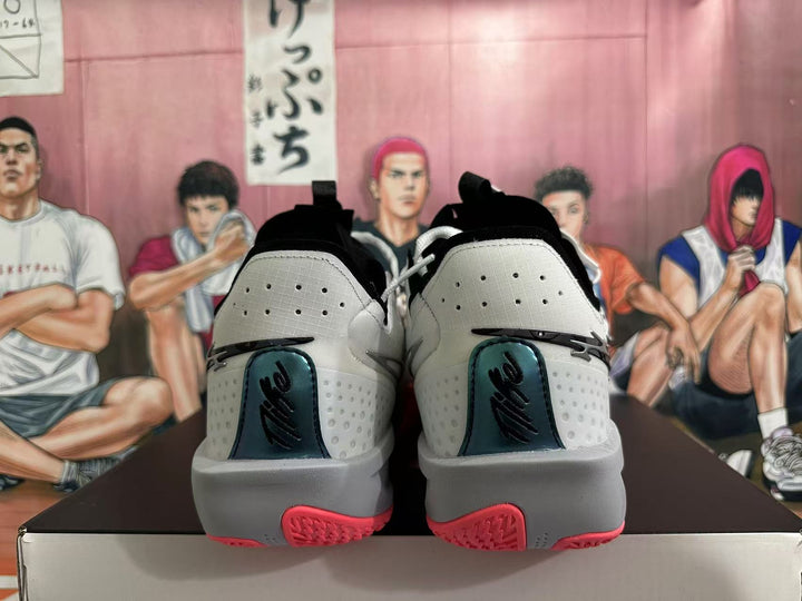 Rear view of white and gray Nike basketball shoes with black heel details and pink outsole accents