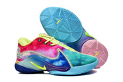 Side and outsole view showing multicolor panels and geometric tread on the blue and pink soles.