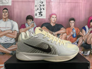 Side view showing the black Nike Swoosh, textured gray upper panels, pale yellow accents, and sculpted midsole.