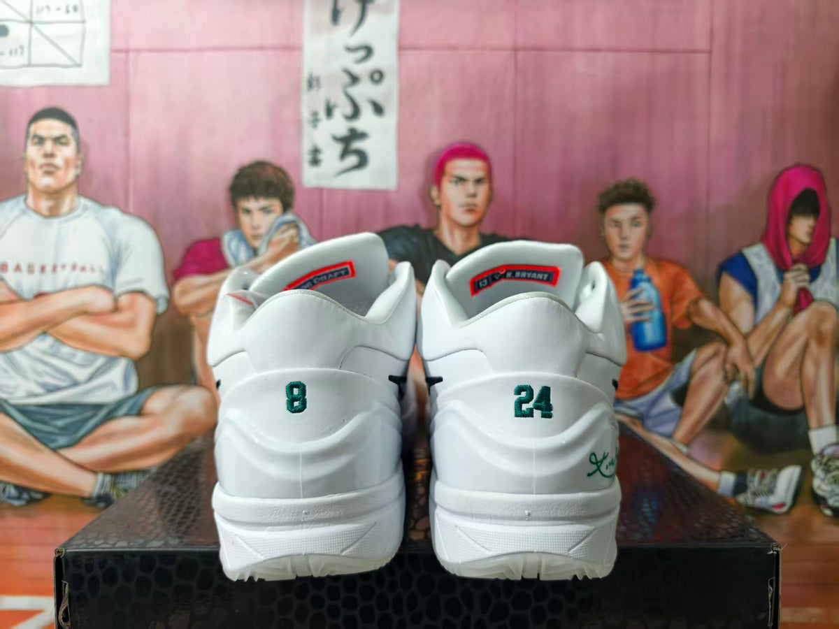 Rear view of white basketball shoes with green 8 and 24 heel details.