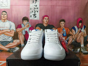 Front view of white basketball shoes showing laces, perforated toe panels, and blue tongue details.