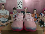 Front view of pink high-top basketball sneakers showing the laces, layered upper, gray toe sections, and pink soles.