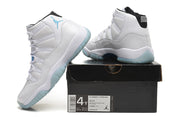 White Jordan high-top sneakers beside a box labeled Air Jordan 11 Retro GS, style code 378038 117.