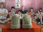 Rear view of the pair showing light olive heel panels, red branding details, and textured outsole sections.