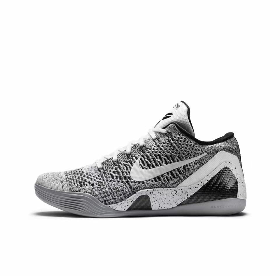 Side view of a grey-and-black Nike Kobe 9 basketball shoe with a textured upper, white Swoosh, and speckled midsole panels.