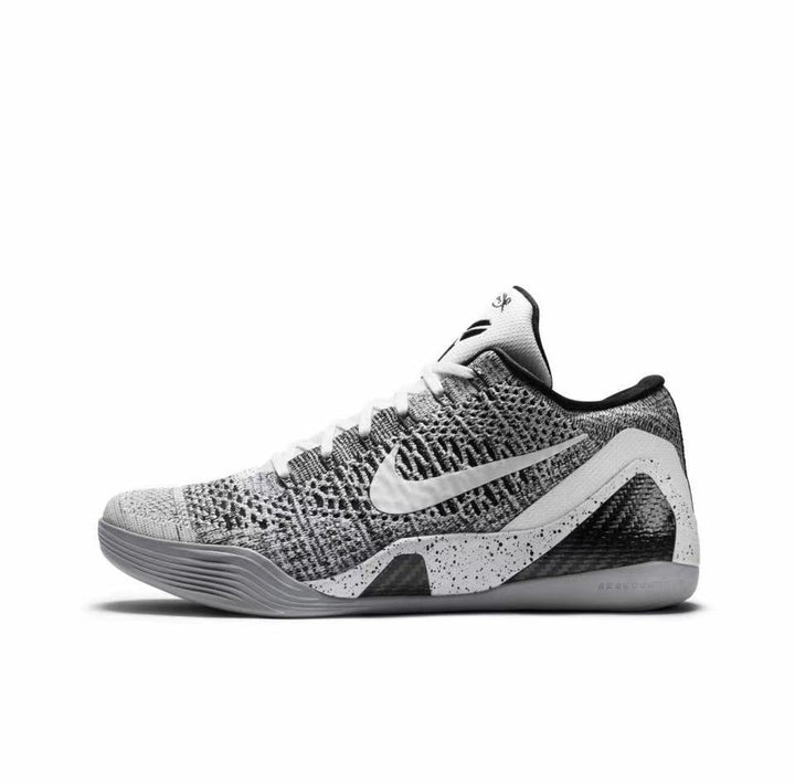 Side view of a grey-and-black Nike Kobe 9 basketball shoe with a textured upper, white Swoosh, and speckled midsole panels.