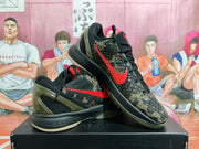 Angled view showing the textured camouflage upper, red Nike Swoosh, black laces, and translucent olive-toned heel.