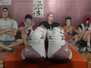 Front view of white and dark red Nike basketball sneakers displayed on an orange shoebox.