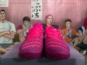 Front view of a pair of pink Nike basketball sneakers showing the laces, mesh-style toe boxes, and contrasting patterned overlays.