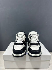 Front view showing paired sneakers with white laces, perforated toe panels and black overlays.