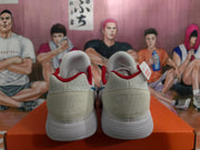Rear view of white Nike sneakers showing red collar accents, textured uppers, and ribbed white outsoles.