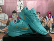 Angled view of lake blue Nike sneakers with gold-toned swooshes, textured side panels, and lace-up fronts.