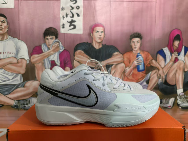 Side view of a light blue, white, and black Nike basketball sneaker displayed on an orange shoebox.
