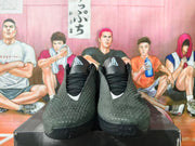 Front view of black basketball shoes with Kobe-style tongue logos