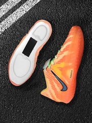 Close angled view of an orange-red Nike sneaker showing the side Swoosh, patterned upper, and detached sole insert.