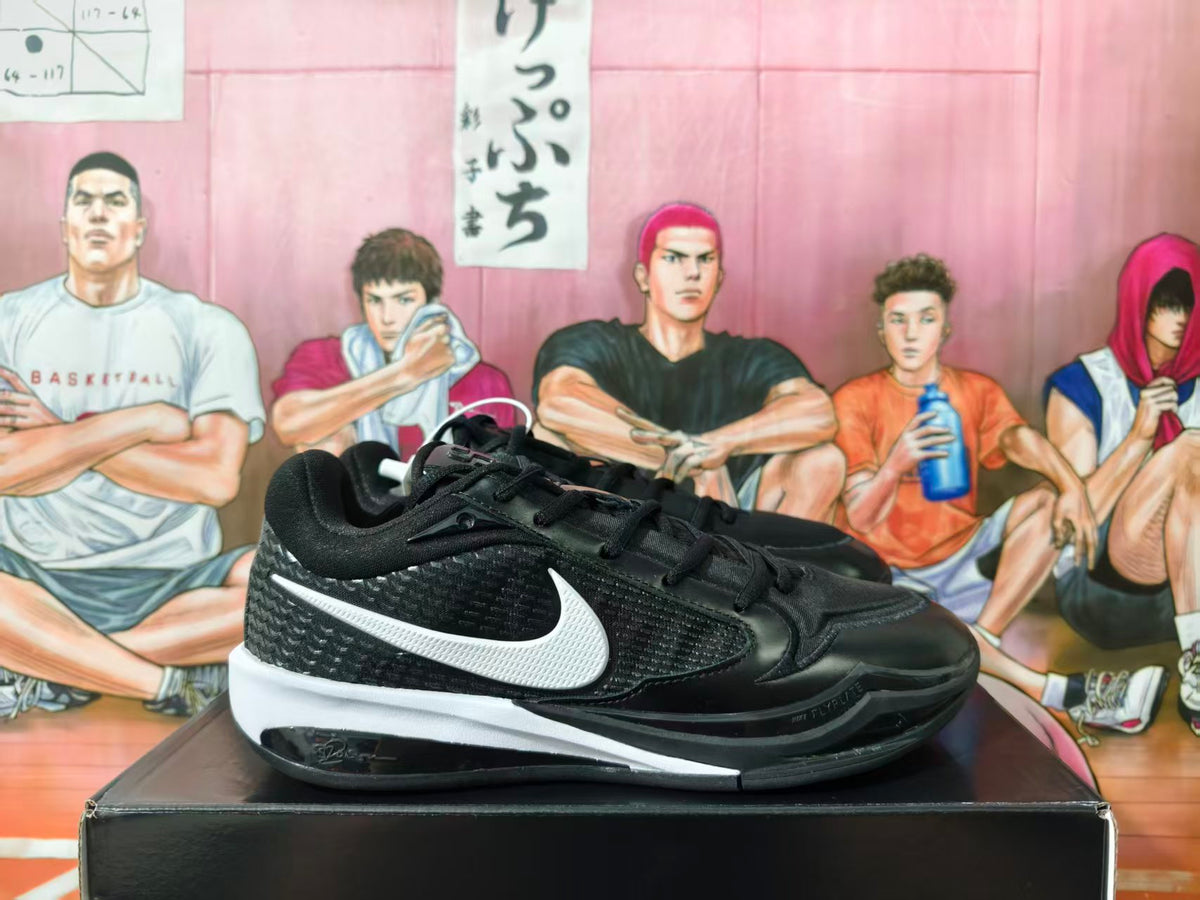 Side view of black and white Nike low-top sneakers displayed on a shoebox.