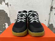 Front view showing black Nike sneakers with white laces and gum-colored outsoles